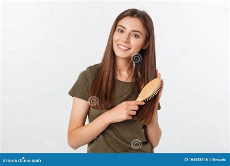 Joven Feliz Peinando Su Largo Y Saludable Pelo Con Fondo Blanco Foto De