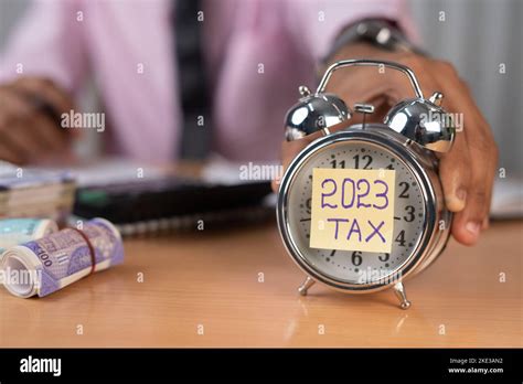 Businessman Placing Timer With 2023 Tax While Calculating Financial