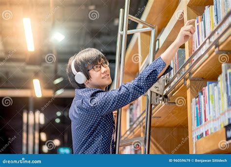 Young Asian Man Reaching To Book In Library Stock Image Image Of