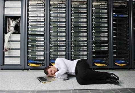 A Man Laying On The Ground In Front Of A Server