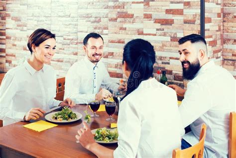 Group Of Laughing Friends Eating At Restaurant And Chatting Stock Image
