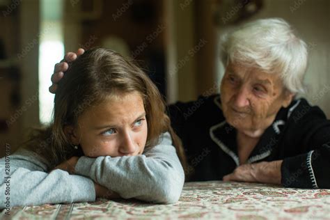 Old Lady Grandma Comforting A Crying Little Girl Granddaughter Stock