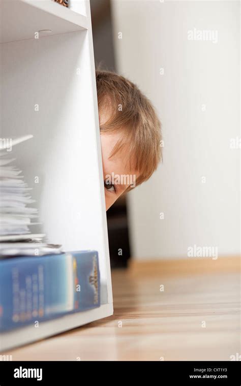 Boy Hiding Behind A Shelf Stock Photo Alamy