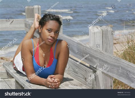African American Girl Lying On A Bench Near The Beach Overlooking The