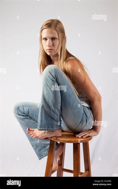 Pretty Blond Woman Sitting With Her Knee Up To Her Chest And Looking At The Camera With A