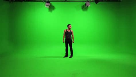 Man Standing In Room And Looking Around Isolated Against Green Screen