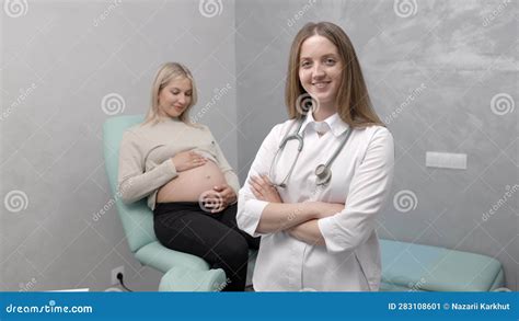 Gynecologist Preparing For An Examination Procedure For A Pregnant Woman Sitting On A Chair In