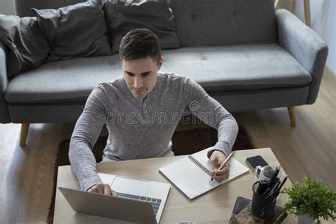 Man Freelancer Sitting On Floor In Living Room And Working With