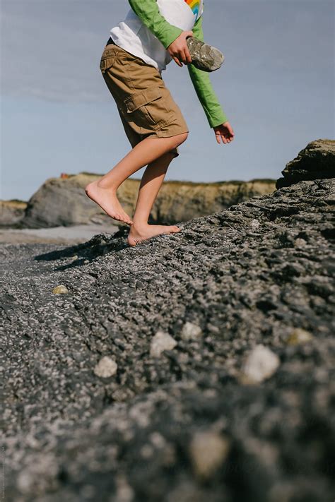 Bare Footed Child Walking On Rocks By Stocksy Contributor Rebecca