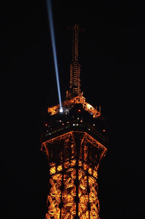 Spotlight Extending From Top Of Illuminated Night View Of Eiffel Tower