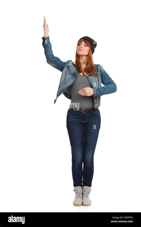 Serious Young Woman In Unbuttoned Jeans Jacket Is Standing Holding