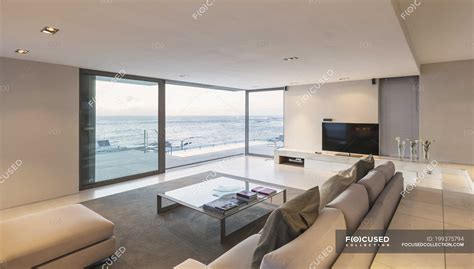 Modern Minimalist Luxury Living Room With Patio Doors Open To Ocean