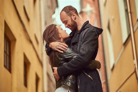 Bearded Man And Brunette Girl Kissing On The Background Of The Old