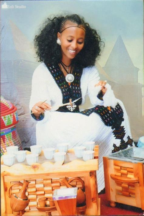 A Beautiful Habesha Woman Serving Coffee Buna And Spinning Cotton In Her Traditional Hand