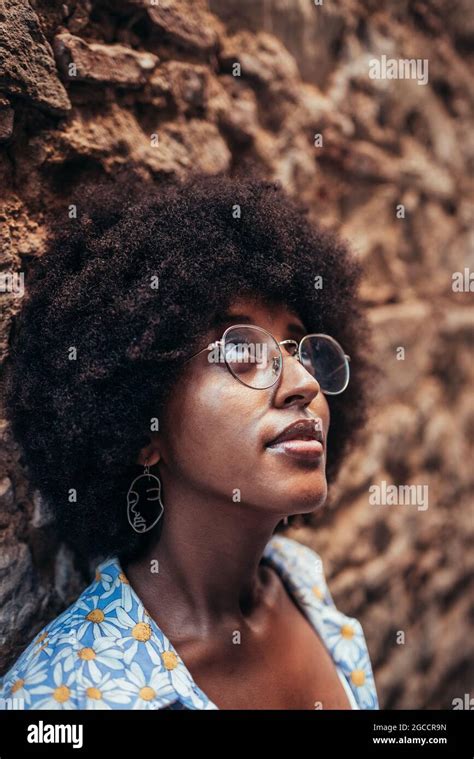 Afro Woman With Glasses And Casual Clothing Looking Up She Is Leaning