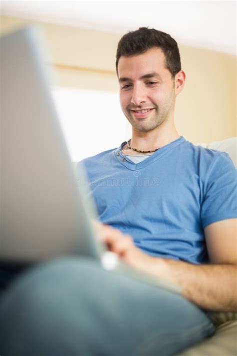 Casual Handsome Man Sitting On Couch Using Looking At Laptop Stock