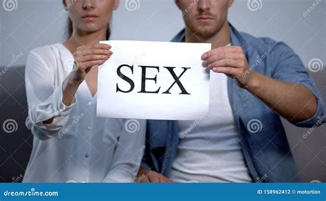 Upset Couple Holding Sex Word On Cardboard Sexual Life Disorder