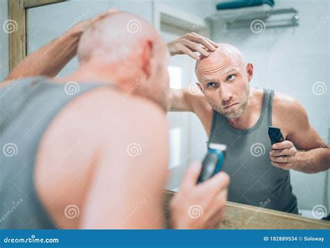 Bald Man Touching His New Style Bald Head Haircut He Made Using An Electric Rechargeable Trimmer