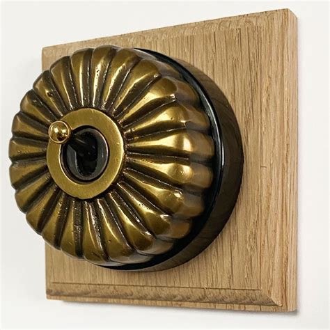Fluted Round Dolly Light Switch 1 Gang Antique Satin Brass Black Base