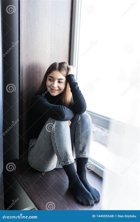 Beautiful Young Woman Sitting At Windowsill At Home Stock Photo Image