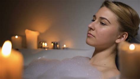 Pensive Woman Lying In Bath With Foam Bubbles And Candles Thinking About Life Stock Footage