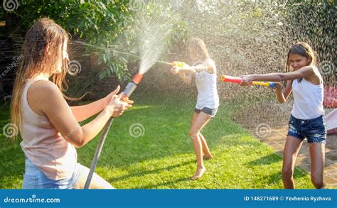Photo Of Happy Children Having Water Gun Fight At House Backyard Garden