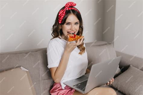 Chica Rizada Glamorosa Comiendo Pizza Con Placer Y Usando La Computadora Mujer Atractiva Pasar