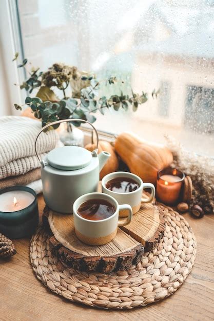 Premium Photo Beautiful Autumn Composition With Burning Candles And Cup Of Tea On Window Sill