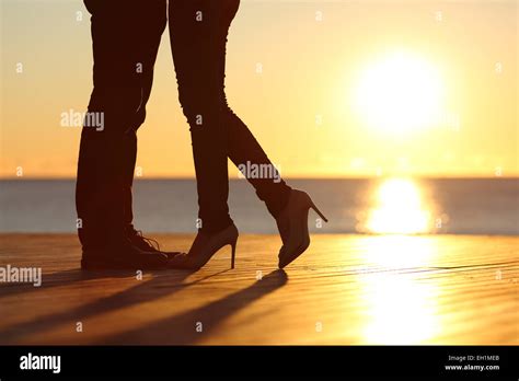 Couple Legs Silhouette Falling In Love Hugging At Sunset On The Beach With The Sun In The