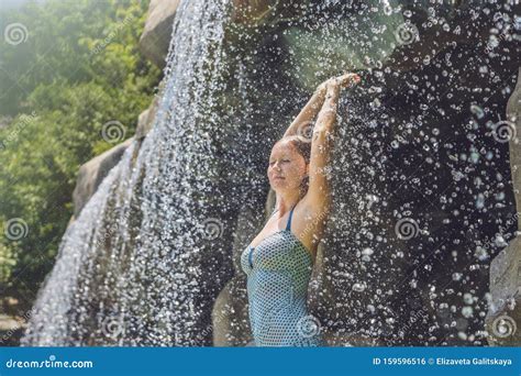 Une Jeune Femme Se Relaxant Sous Une Cascade Dans Un Aquapark Photo