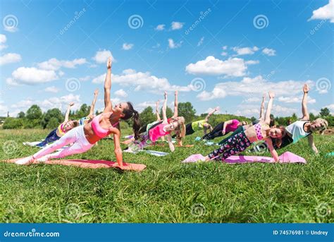 Group Of Fit Girls Going Side Plank Exercise In Nature On A Sunny Day