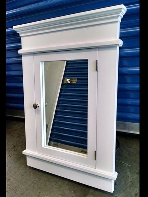 A White Cabinet With A Mirror On Top