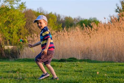Happy Caucasian Child Boy Running On Meadow Grass Summer In Nature
