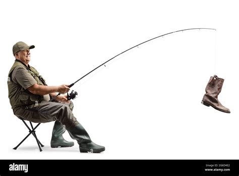 Mature Fisherman Sitting On A Chair With A Fishing Rod And An Old Boot