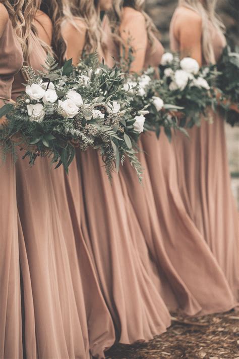 The Bridesmaids Are Holding Their Bouquets And Wearing Long Dresses