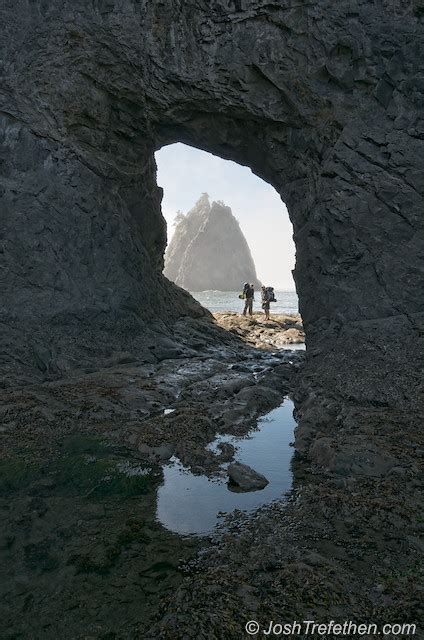 To get to this area, you have to navigate yourself over many. Hikers peer through the Hole in the Wall at Rialto Beach ...