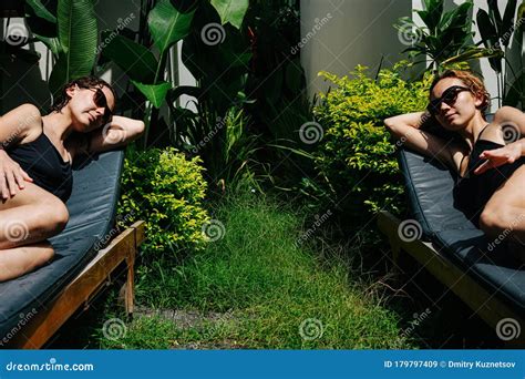 Two Napping Young Women Relaxing On Deck Chairs On Terrace Stock Image