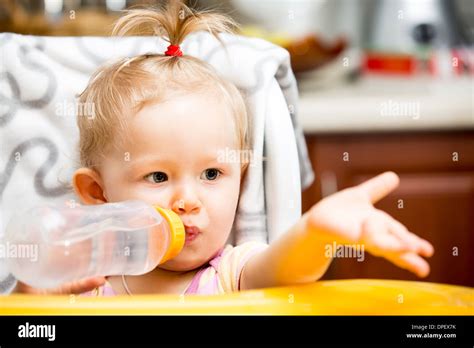 Child Girl With Bottle With Infant Formula On Kitchen Use It For Child