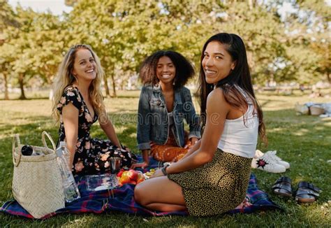 Smiling Multiracial Female Friends Sitting Together On Blanket Over The