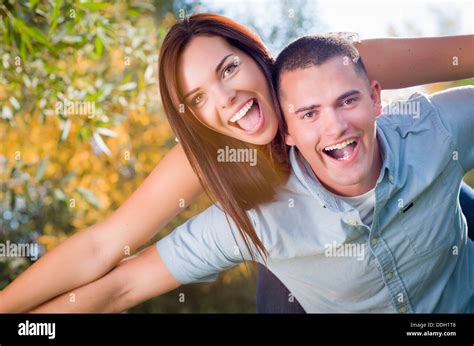 Happy Mixed Race Romantic Couple Piggyback Portrait In The Park Stock