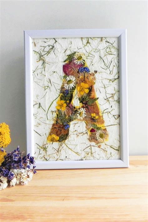 A Framed Photograph Of A Bear Surrounded By Wildflowers On A Table Next