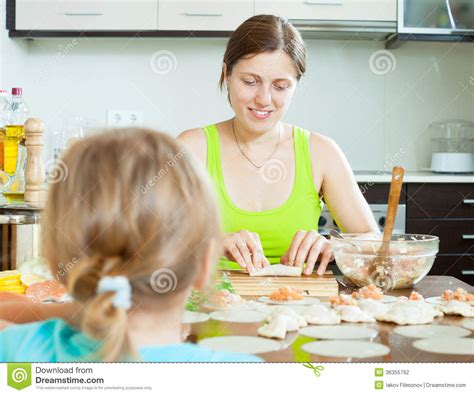 Woman With An Obedient Child Making Fish Salmon Dumplings