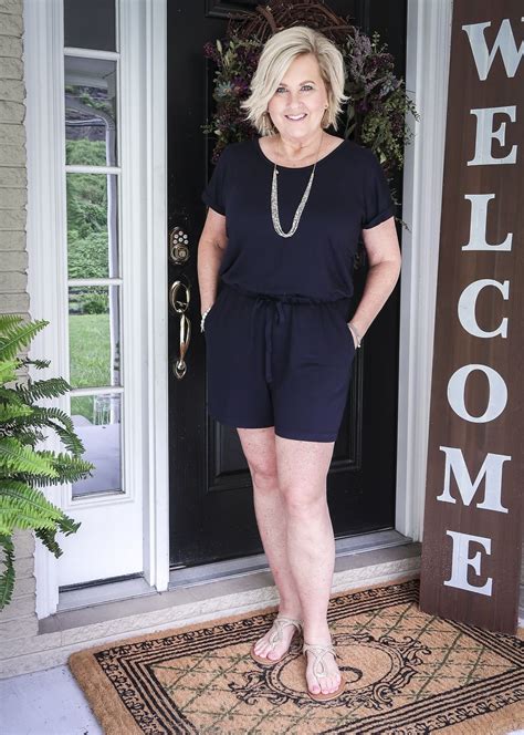 Fashion Blogger 50 Is Not Old Is Wearing A Cute Navy Romper With Gold