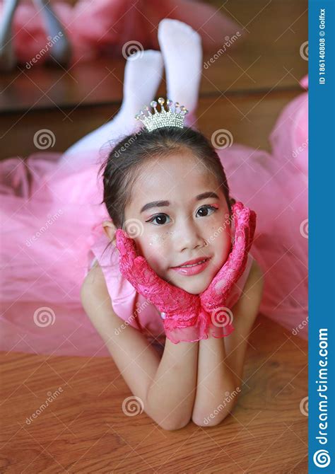 Portrait Of Little Ballerina Girl In A Pink Tutu Lying On The Floor