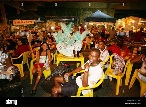Environmental Streetscape Of Smiling Dancers Sitting At Food Stall