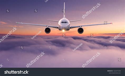 Commercial Airplane Jetliner Flying Above Dramatic Stock Photo