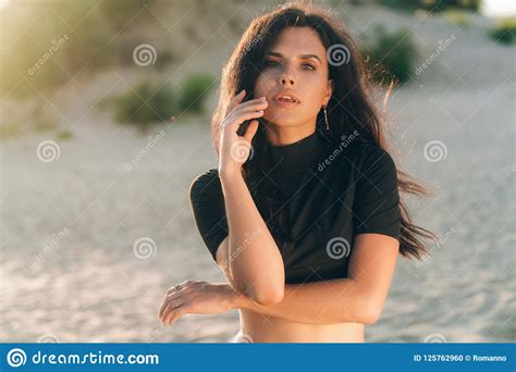 Portrait Of Sensual Girl Has Smooth Tanned Skin Posing On Beach Wind