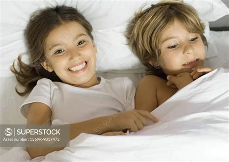 Brother And Sister Lying In Bed Together Superstock