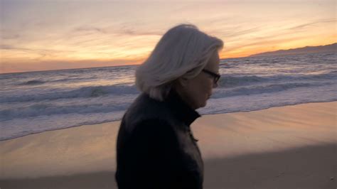 Happy Mature Fit Active 60s Woman Walking And Enjoying A Sunset On