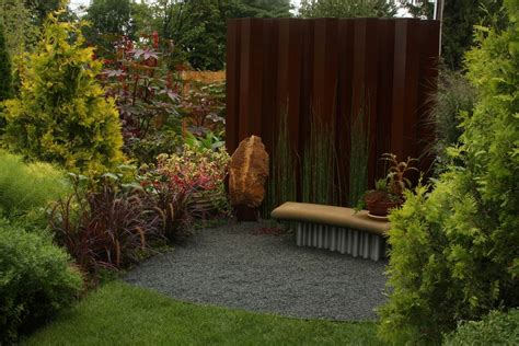 Installing a screen planting often requires the purchase of many plants or trees bought all at once. A rusty privacy screen inspires a planting - FineGardening